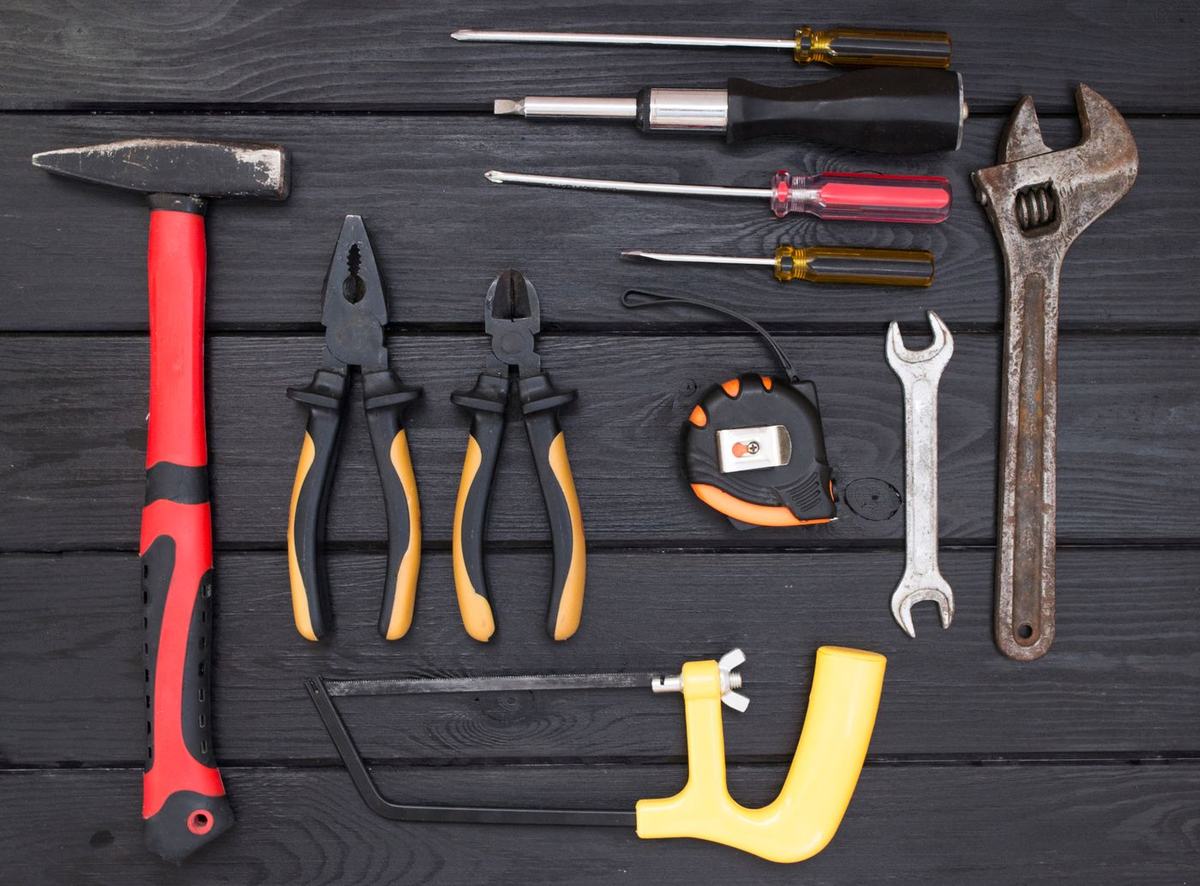 Hand tools laid out on a dark workbench